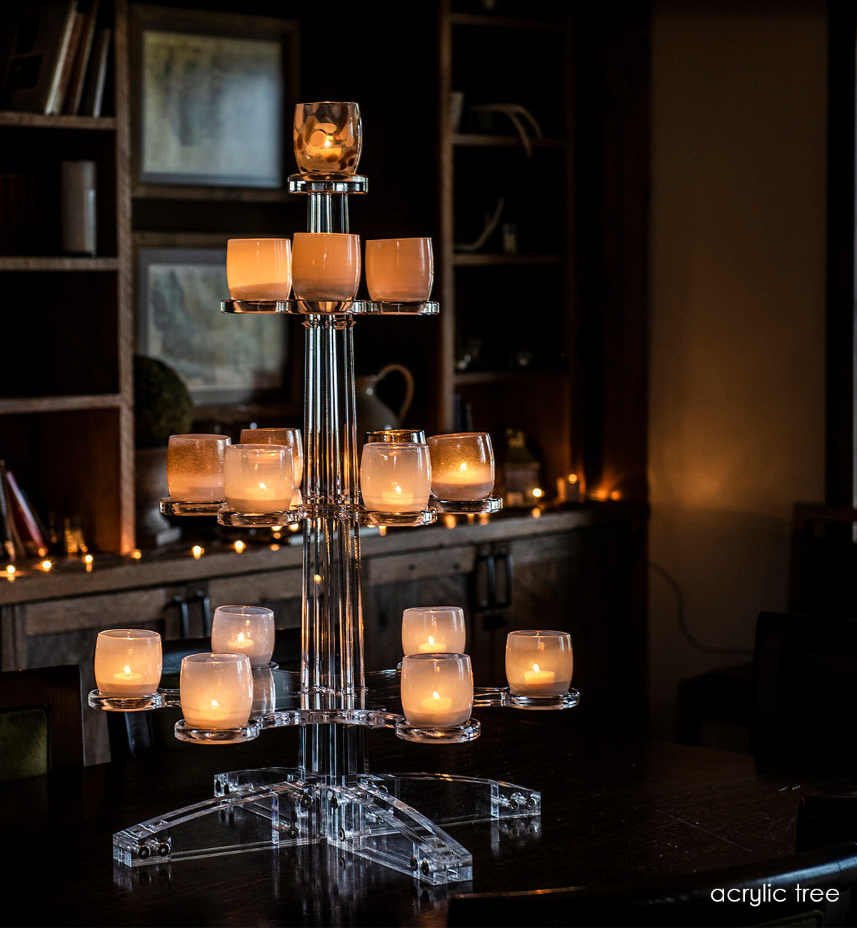 acrylic tree stand for hand-blown glass votive candle holders lit with tealights in a dark room.