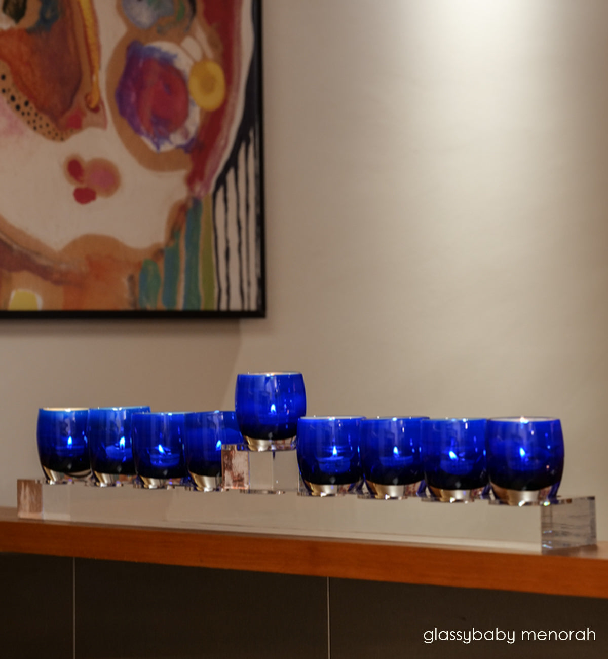 menorah on acrylic stand, give blue with metallic interior, hand-blown glass votive candle holders on the menorah