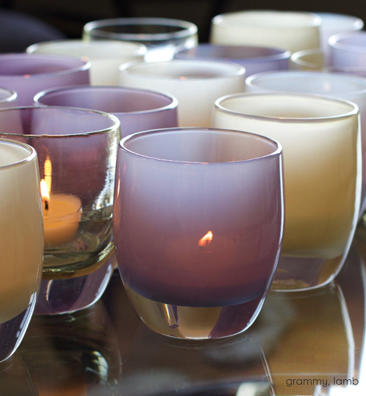 grammy, soft purple hand-blown glass votive candle holder. Paired with lamb on a reflective surface.