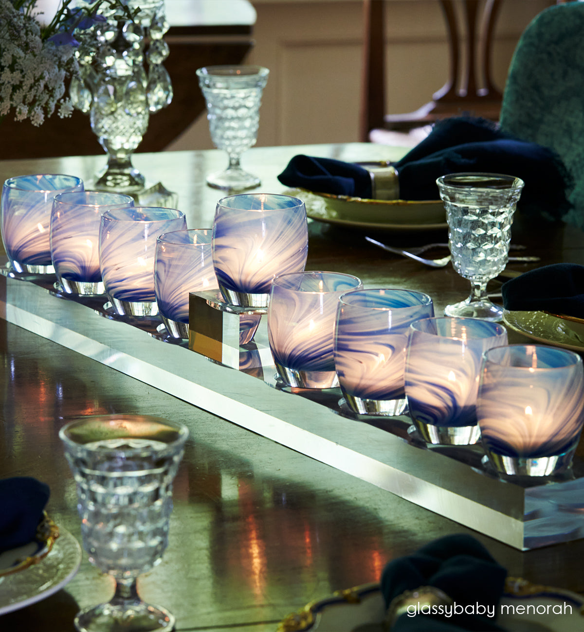 reflection glassybaby on a glassybaby menorah on a set dining room table.