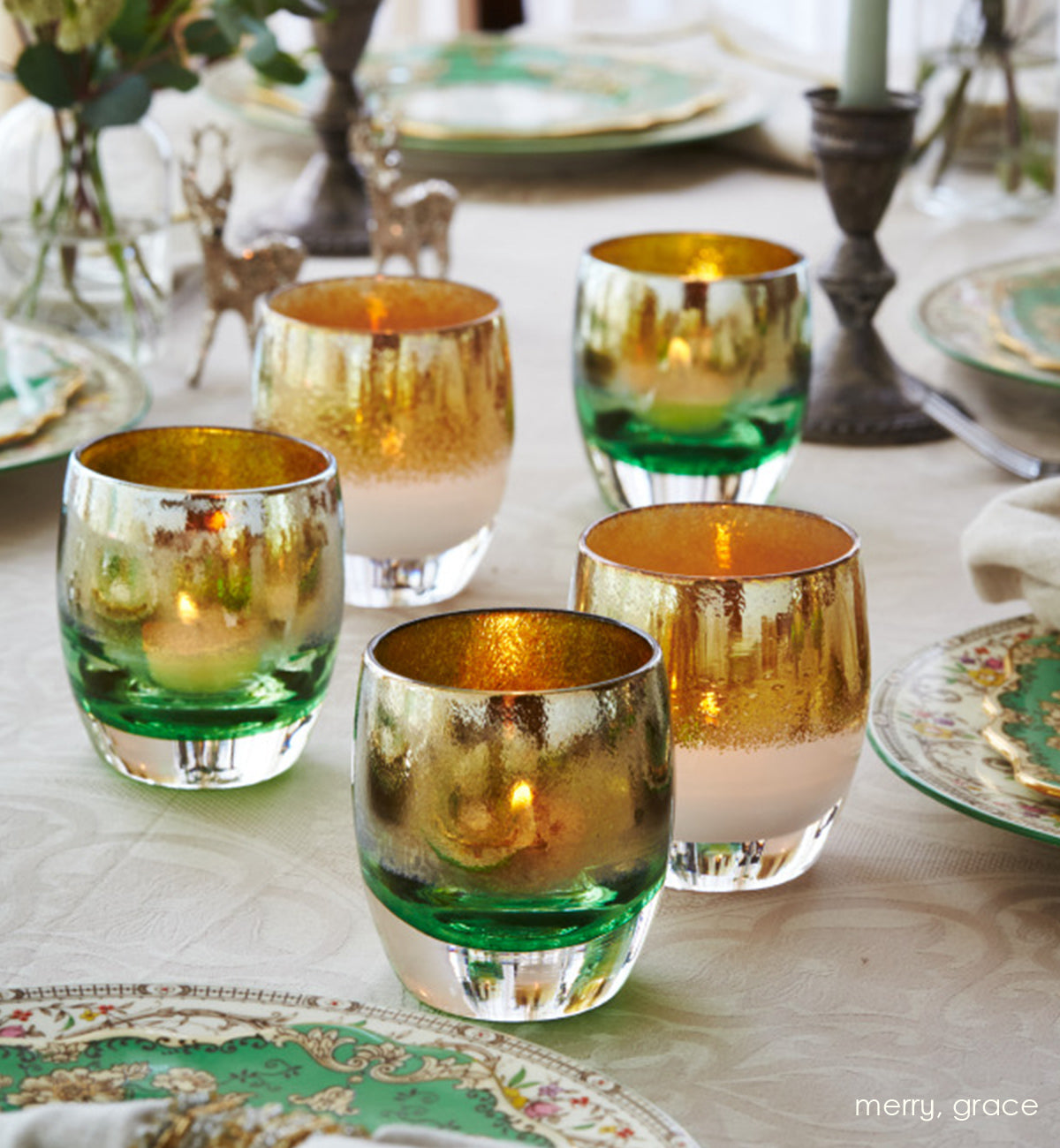 merry, green with gold shimmer hand-blown glass votive candle holders on a dining room table with grace.